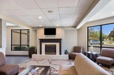 a living room with a fireplace and a tv at Quality Inn Albany Colonie in Albany