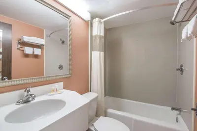 a bathroom with a sink and a toilet and a mirror at Vernon Motel in Vernon