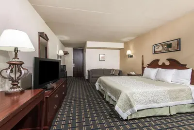 a hotel room with a bed and a flat screen tv at Vernon Motel in Vernon