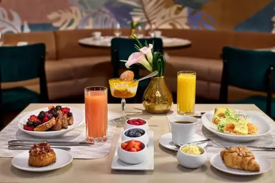 a table with plates of breakfast foods and drinks at The St. Regis New York in New York