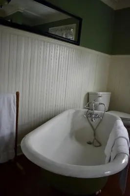 a white bath tub in a bathroom with a mirror at Harbour House Inn B&B in Cheshire