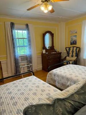 a bedroom with two beds and a mirror and a window at Harbour House Inn B&B in Cheshire