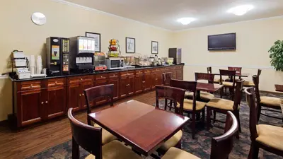 a restaurant with tables and chairs and a coffee shop at Best Western Queens Court in Queens