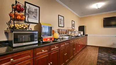 a room with a counter with a microwave and a television at Best Western Queens Court in Queens