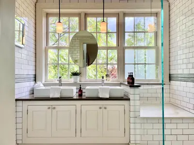 a bathroom with two sinks and a large window at Wm. Farmer and Sons in Hudson