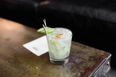 a drink with a lime on top of a table at Wm. Farmer and Sons in Hudson
