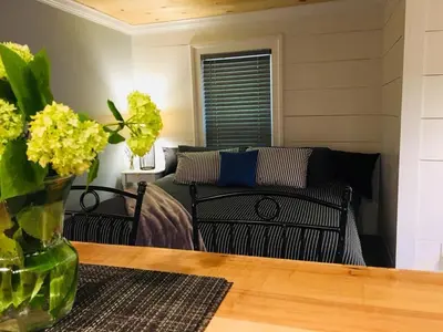 a living room with a couch and a table with flowers at Wind in the Willows Overnight in Jefferson