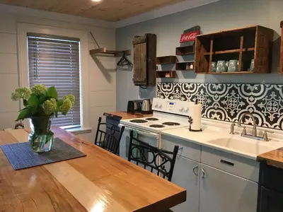 a kitchen with a table with a vase of flowers on it at Wind in the Willows Overnight in Jefferson
