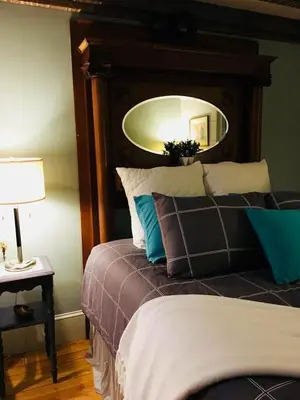 a bedroom with a bed with a mirror above it at Wind in the Willows Overnight in Jefferson