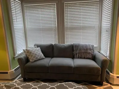 a couch sitting in a living room with windows at Wind in the Willows Overnight in Jefferson