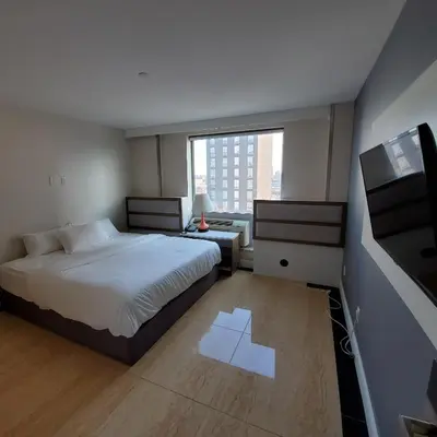a bedroom with a large bed and a window at Mayfair Inn and Suites in Queens