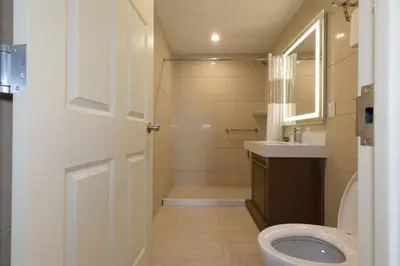 a bathroom with a toilet and a sink at Mayfair Inn and Suites in Queens