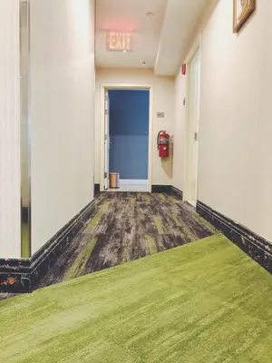 an empty hallway with a exit sign on the wall at Mayfair Inn and Suites in Queens