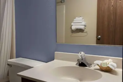 a bathroom with a sink and a toilet and a mirror at Super 8 by Wyndham Cromwell/Middletown in Cromwell