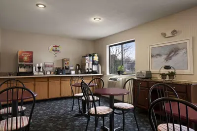 a waiting room with a table and chairs and a bar at Super 8 by Wyndham Cromwell/Middletown in Cromwell