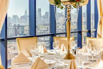 a table in a restaurant with a view of the city at Vista LIC Hotel, Premier Collection by Best Western in Queens