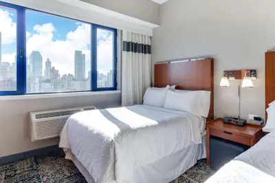 a hotel room with two beds and a large window at Vista LIC Hotel, Premier Collection by Best Western in Queens