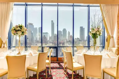 a restaurant with white tables and chairs and a large window at Vista LIC Hotel, Premier Collection by Best Western in Queens
