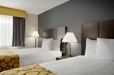 a hotel room with two beds and two lamps at Baymont by Wyndham Branford/New Haven in Branford