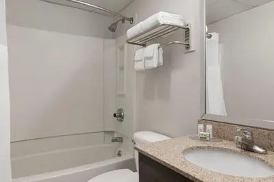 a bathroom with a sink and a toilet and a tub at Baymont by Wyndham Branford/New Haven in Branford