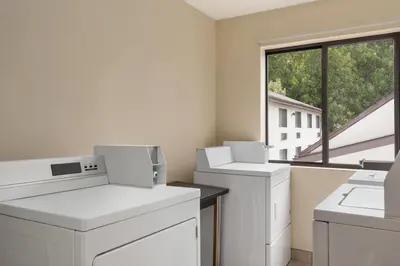 a room with white washing machines and a window at Baymont by Wyndham Branford/New Haven in Branford