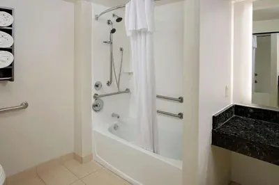 a white bathroom with a shower and a tub at Homewood Suites by Hilton Hartford-Farmington in Farmington