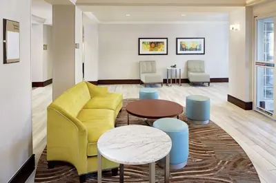 a living room with a yellow couch and a table at Homewood Suites by Hilton Hartford-Farmington in Farmington