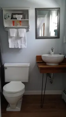a bathroom with a sink and a toilet and a mirror at Harwood Hill Motel in Bennington