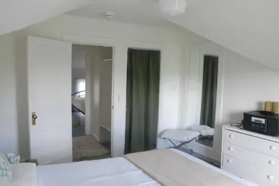 a bedroom with a bed and a dresser and a mirror at Harwood Hill Motel in Bennington
