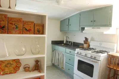 a kitchen with blue cabinets and a stove at Harwood Hill Motel in Bennington