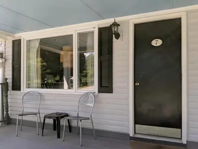 two chairs and a table on the front porch of a house at Harwood Hill Motel in Bennington