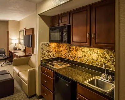 a small kitchen with a sink and a microwave at Quality Suites NYC Gateway in North Bergen