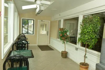 a porch with chairs and plants in a building at Whitney Inn & Suites in Hamden