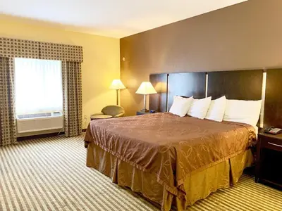 a hotel room with a large bed and a window at Whitney Inn & Suites in Hamden