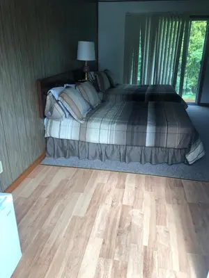a bedroom with a bed and a wooden floor at Michael Dee's Motel in East Durham