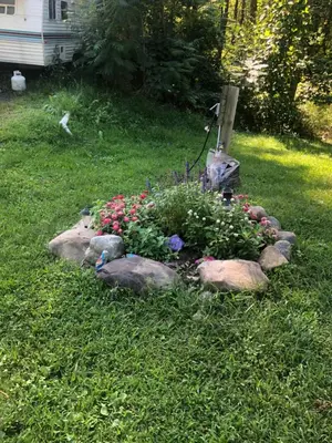a garden with flowers and rocks in the grass at Michael Dee's Motel in East Durham