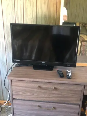 a television on a wooden dresser with a remote control at Michael Dee's Motel in East Durham