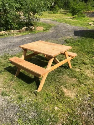 a wooden picnic table sitting on the grass at Michael Dee's Motel in East Durham