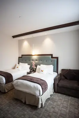 a hotel room with two beds and a couch at Aura Hotel Brooklyn in Brooklyn