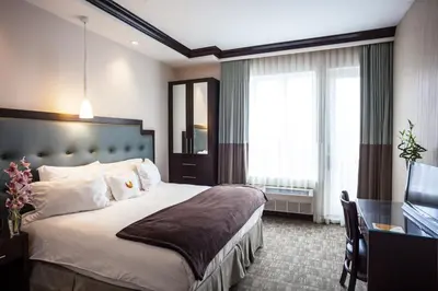 a hotel room with a large bed and a desk at Aura Hotel Brooklyn in Brooklyn