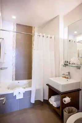 a bathroom with a white tub and a sink and a bath tubermott at Aura Hotel Brooklyn in Brooklyn
