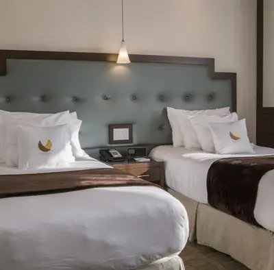 a hotel room with two beds with white pillows at Aura Hotel Brooklyn in Brooklyn