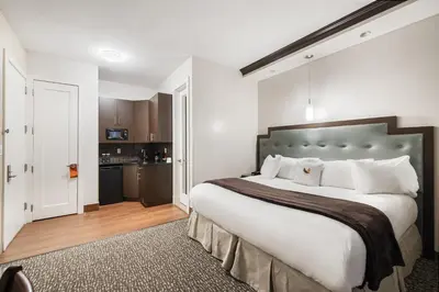 a bedroom with a large bed and a kitchen at Aura Hotel Brooklyn in Brooklyn
