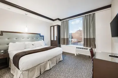 a hotel room with a bed and a large window at Aura Hotel Brooklyn in Brooklyn