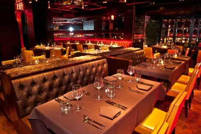 a restaurant with tables and chairs with wine glasses at Sanctuary Hotel New York in New York