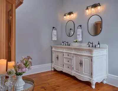 a bathroom with a white vanity and two mirrors at Landmark Inn in Cooperstown
