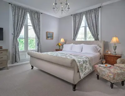 a bedroom with a large bed and a chair at Landmark Inn in Cooperstown