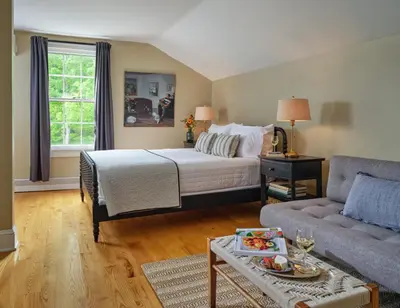 a bedroom with a bed and a couch at Landmark Inn in Cooperstown