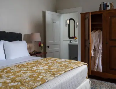 a bedroom with a bed and a mirror and a closet at Landmark Inn in Cooperstown