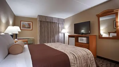 a hotel room with a bed and a flat screen tv at Best Western Clifton Park in Clifton Park